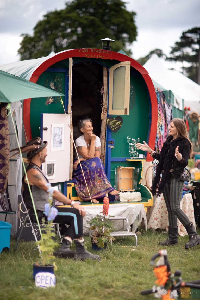 Green Gathering - people chatting at the porch of a vardo